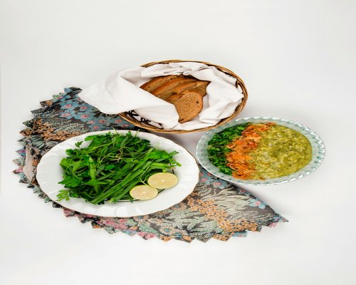 A colorful healthy plate containing whole grain bakery bread and green fresh lettuce cuts